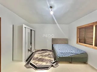 Quarto com cama e guarda-roupa em ambiente claro.