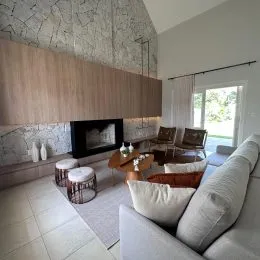 Sala de estar com lareira e sofá de cor clara.