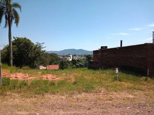 Vista externa da propriedade com muro de tijolos e vegetação