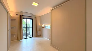 Sala de estar com piso de madeira clara e portas de vidro que dão acesso ao exterior.
