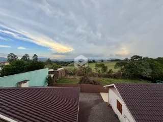 Vista panorâmica da propriedade com paisagem rural ao fundo.