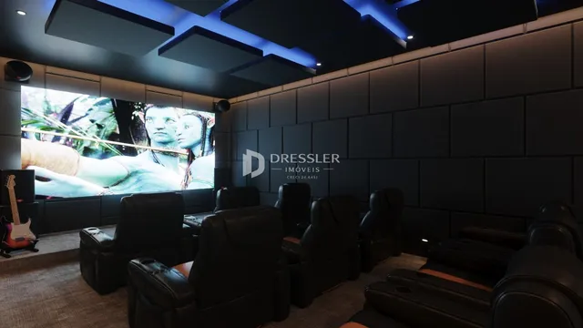 Sala de estar com sofás de couro e tela grande em um imóvel.