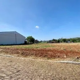 Vista aérea de um campo aberto e seco sob um céu azul claro.