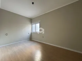 Foto de uma sala com piso de madeira clara e paredes neutras.