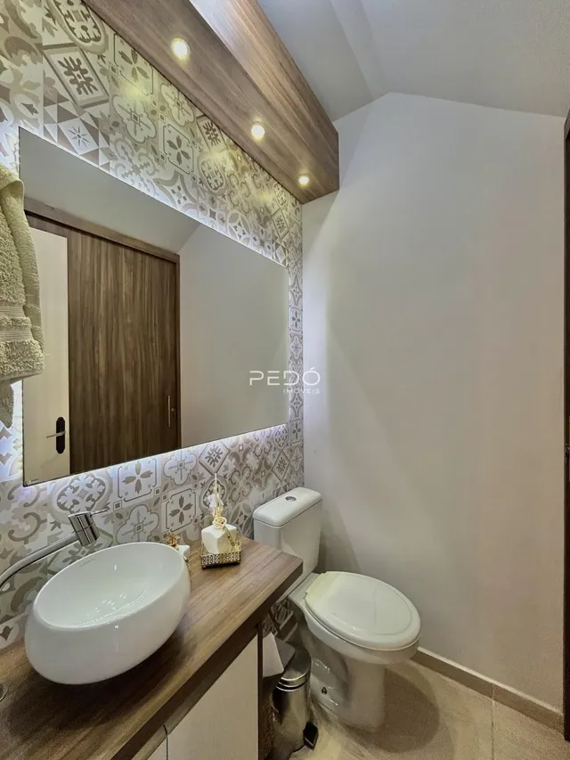 Foto de um banheiro moderno com bancada de madeira e azulejos decorativos.