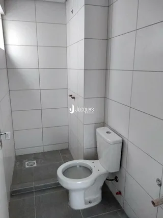 Foto de um banheiro com revestimento cerâmico nas paredes e piso.