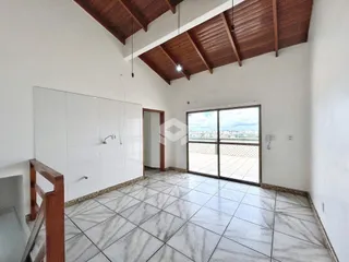 Imagem de uma sala com teto de madeira e piso de cerâmica em uma residência.