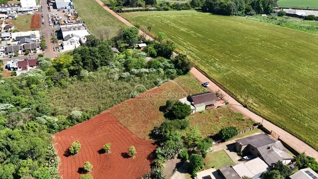 Vista aérea de uma propriedade mostrando um campo aberto e vegetação ao redor.