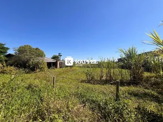 Vista externa de um campo gramado sob um céu azul claro.