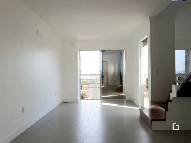 Espaço interno com paredes brancas e piso claro de uma residência.