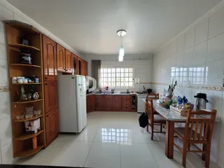 Foto de uma cozinha com armários de madeira e piso claro.
