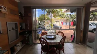 Sala de jantar com vista para o quintal através de grandes portas de vidro.