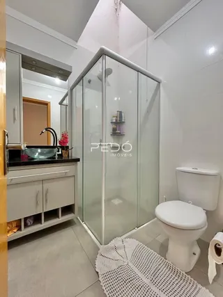 Foto de um banheiro com box de vidro e vaso sanitário em Lajeado.
