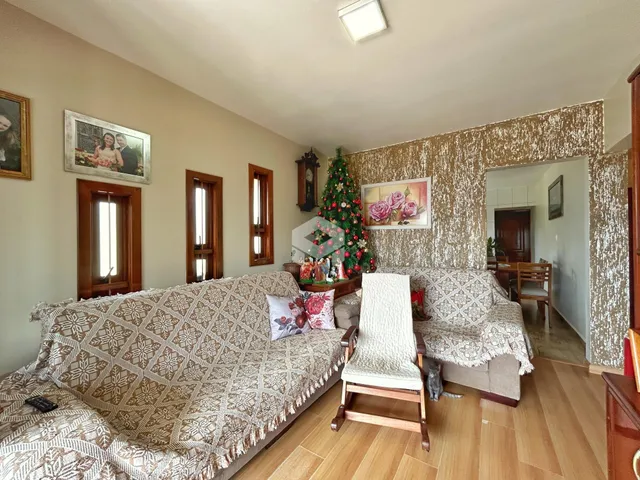 Sala de estar com dois sofás e piso de madeira em uma residência.