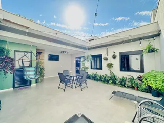 Área externa com mesa de jantar e ambiente de lazer.