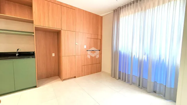 Interior de uma sala com armários de madeira e piso claro.