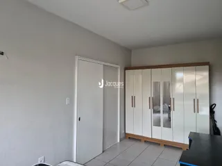 Vista interna de um corredor com armário branco e piso de cerâmica.