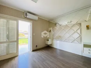 Sala de estar com piso de madeira e porta de vidro abrindo para o exterior.