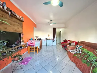Sala de estar com paredes laranjas e piso de cerâmica.