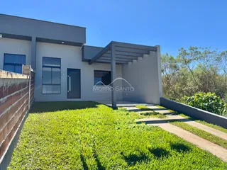 Fachada de uma casa moderna com jardim gramado e calçada em Lajeado.