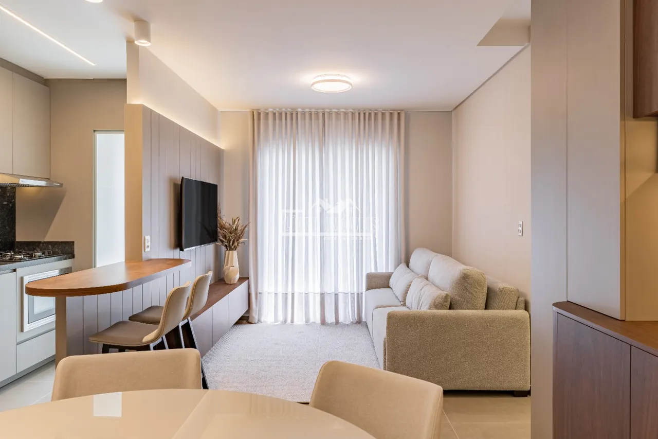 Sala de estar com sofá e janela em um apartamento.