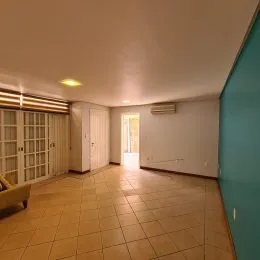 Foto de um corredor interno com piso de cerâmica claro e paredes brancas.
