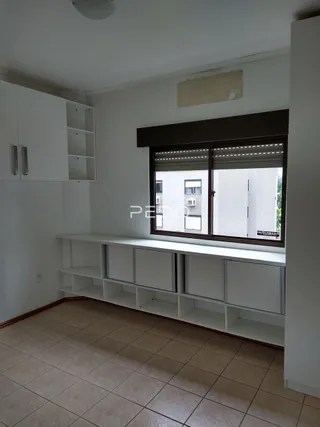 Interior de uma sala com piso de cerâmica e armários brancos.