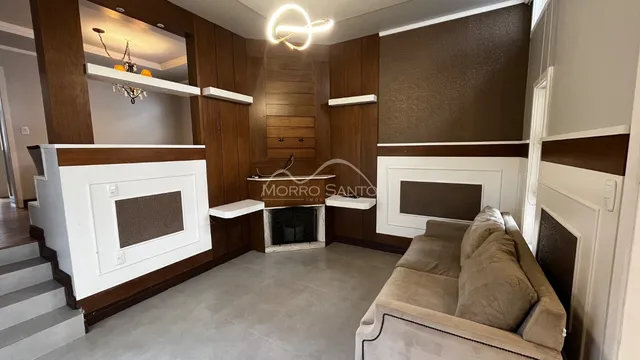 Uma sala de estar com painéis de madeira e lareira é visível na propriedade.