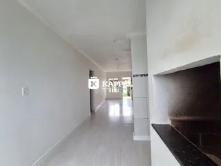 Corredor interno com piso claro e paredes brancas.