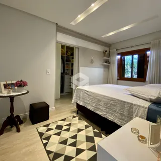 Quarto com cama e janela em ambiente claro.