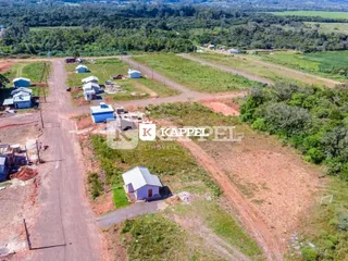Vista aérea de um terreno rural com vegetação e estradas de terra.
