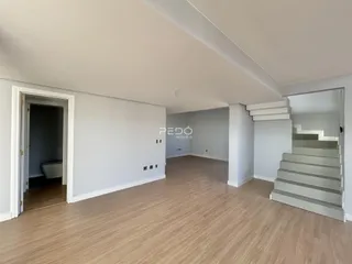 Hall de entrada com piso de madeira e acesso a um corredor.