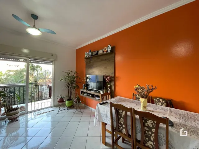 Sala de estar com parede laranja e vista para o exterior.