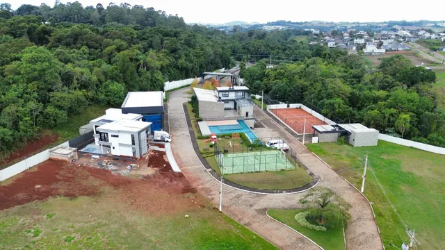 Vista aérea de uma propriedade em construção com piscina e áreas verdes.
