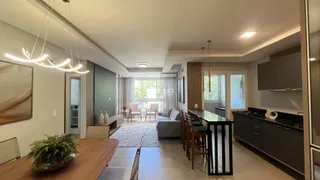 Ambiente interno de uma sala de estar moderna com piso de madeira clara.