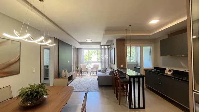 Ambiente interno de uma sala de estar moderna com piso de madeira clara.