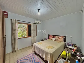 Quarto com janela e cama em ambiente claro.