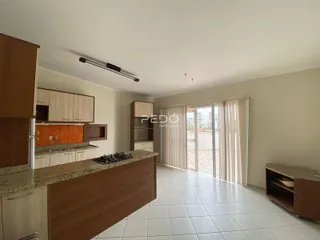 Vista de uma cozinha com armários de madeira e piso cerâmico claro.