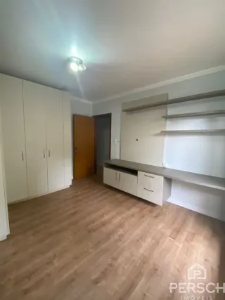 Interior com piso de madeira e armários em uma sala.