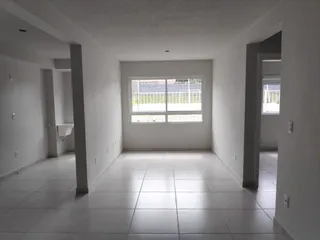 Foto de um corredor interno com piso claro e paredes brancas.