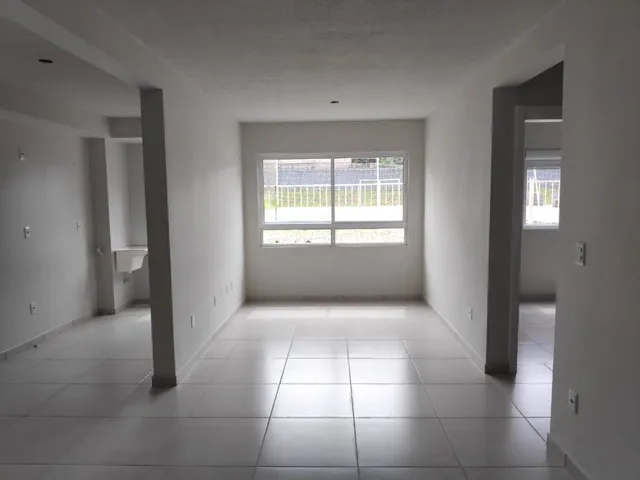 Foto de um corredor interno com piso claro e paredes brancas.
