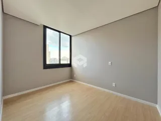 Foto de uma sala com piso de madeira clara e grande janela.