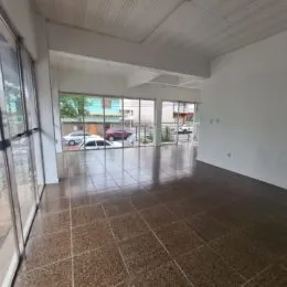 Sala de estar com piso de cerâmica e grandes janelas de vidro.