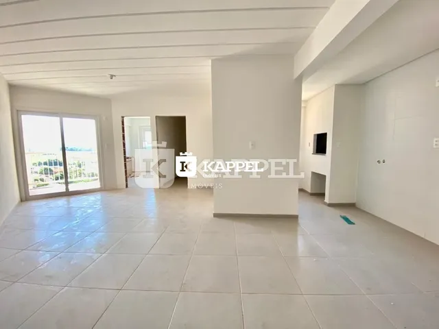 Sala ampla com piso de cerâmica e paredes brancas.
