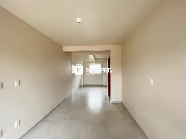 Corredor interno com piso de cerâmica e paredes claras.