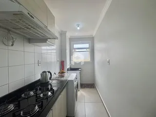 Cozinha com revestimento cerâmico e bancada escura.