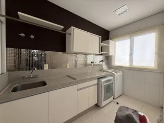 Foto de uma cozinha moderna com bancada e eletrodomésticos brancos.