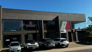 Fachada de um prédio residencial em Lajeado, Brasil, com carros estacionados na frente.