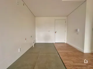 Vista de um corredor interno com piso de concreto e madeira.