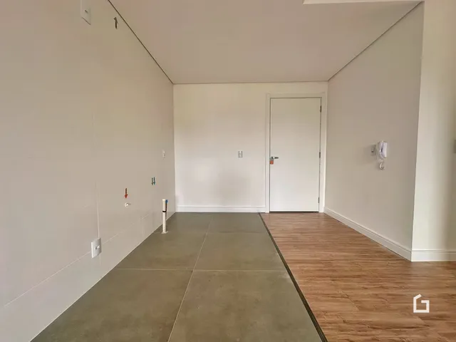 Vista de um corredor interno com piso de concreto e madeira.